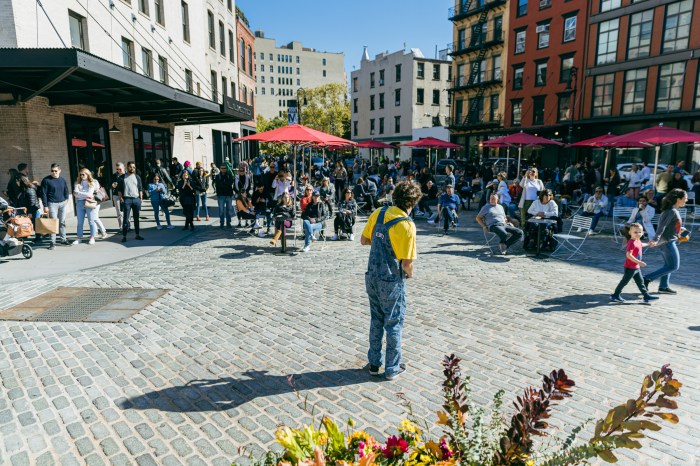 people enjoying the outdoors in the daytime with red umbrellas out in the Meatpacking District