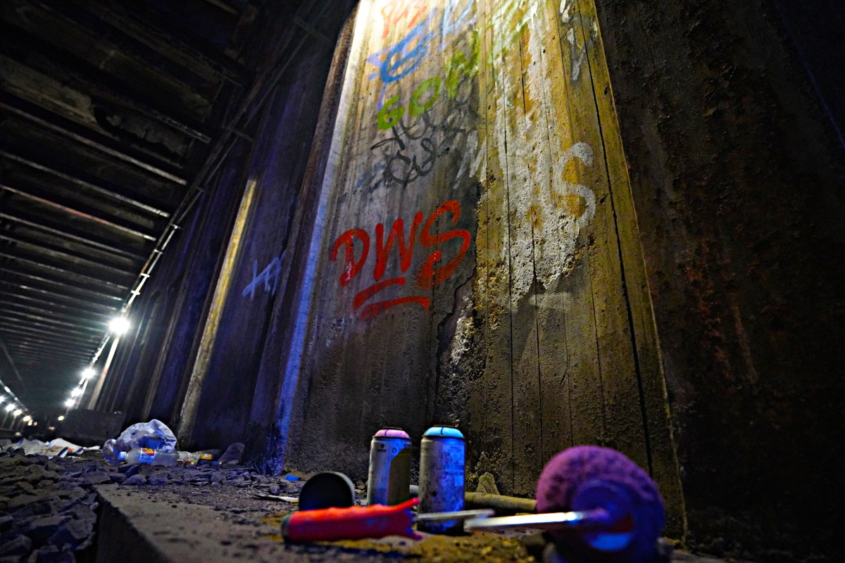 Following along the track in the dim, murky flashlight, the team came upon an array of strewn spray cans, splattered paint, rollers, littering the roadbed