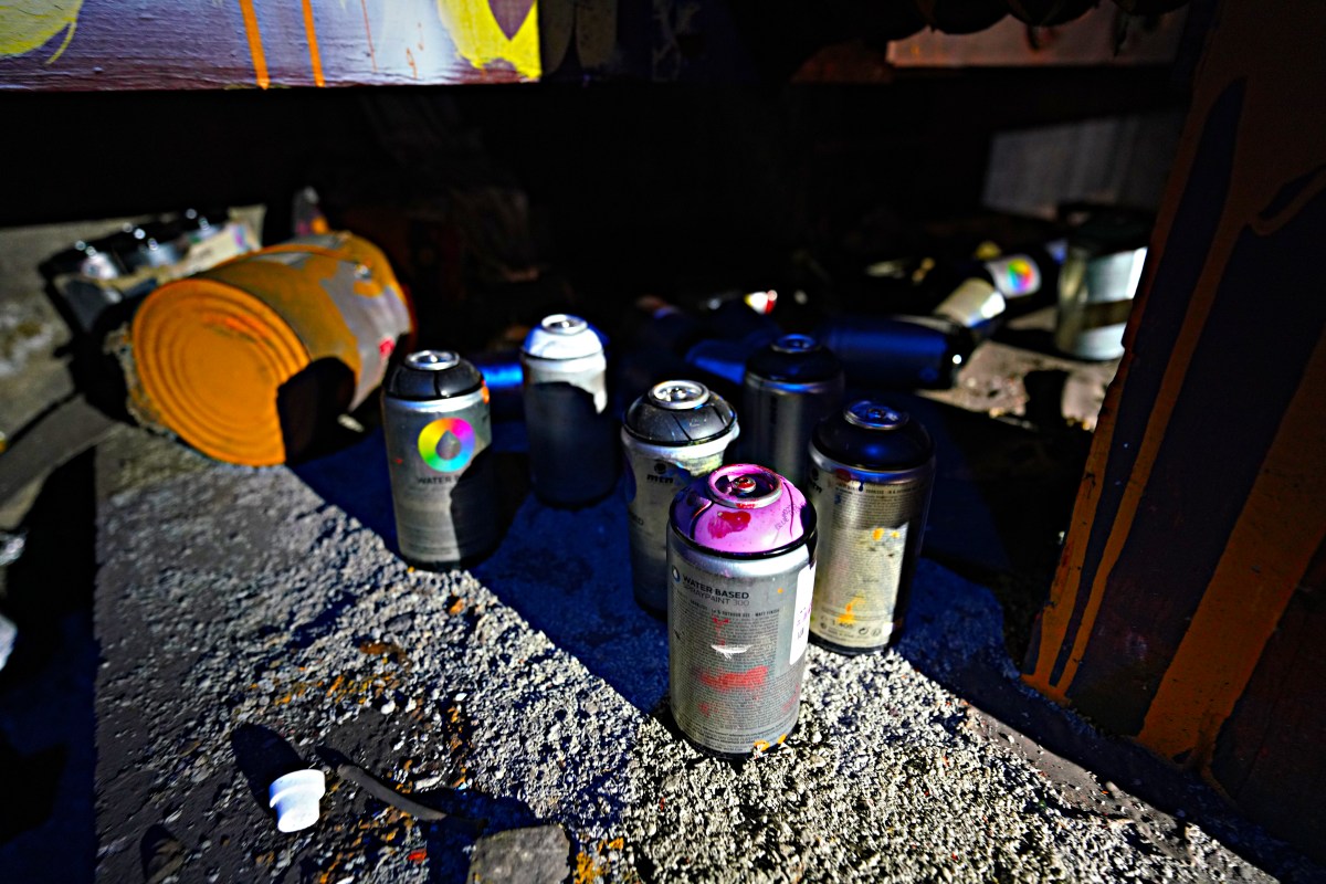 Following along the track in the dim, murky flashlight, the team came upon an array of strewn spray cans, splattered paint, rollers, littering the roadbed