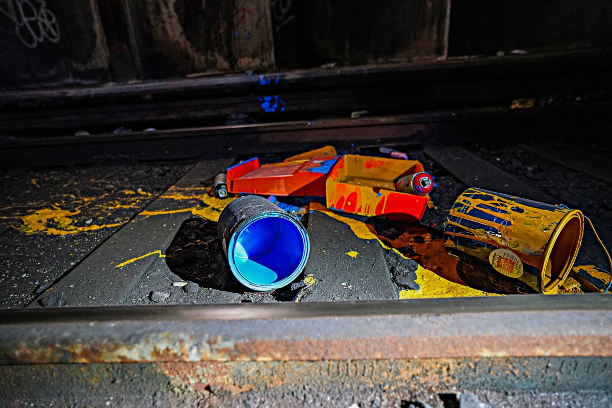 Following along the track in the dim, murky flashlight, the team came upon an array of strewn spray cans, splattered paint, rollers, littering the roadbed