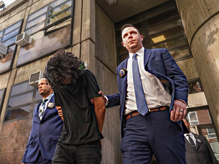 Teen suspect in Harlem fire extinguisher attack bows head while handcuffed and escorted by NYPD detective