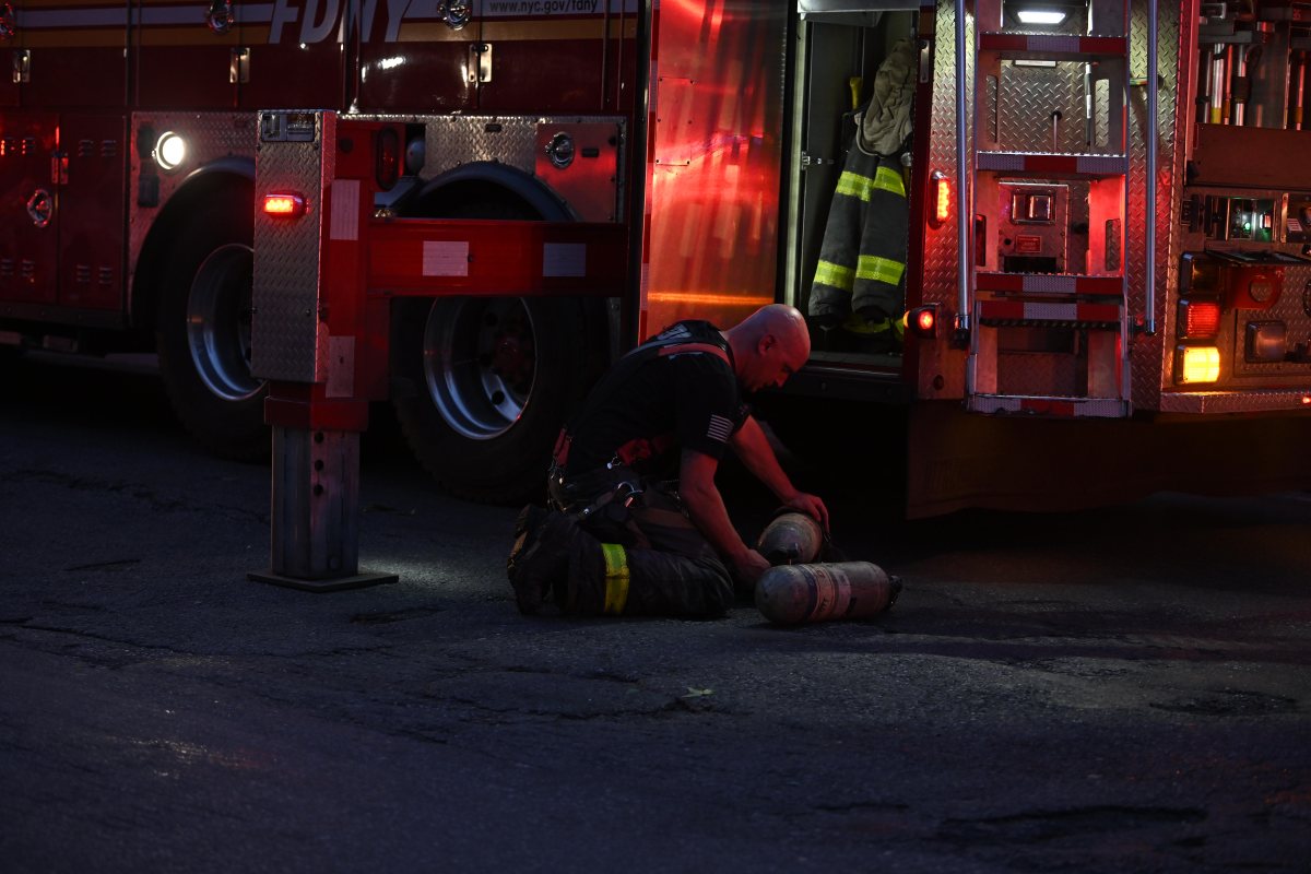A firefighter swaps out air cylinders after operating an apartment fire at 200 Linden Blvs.Photo by Lloyd Mitchell