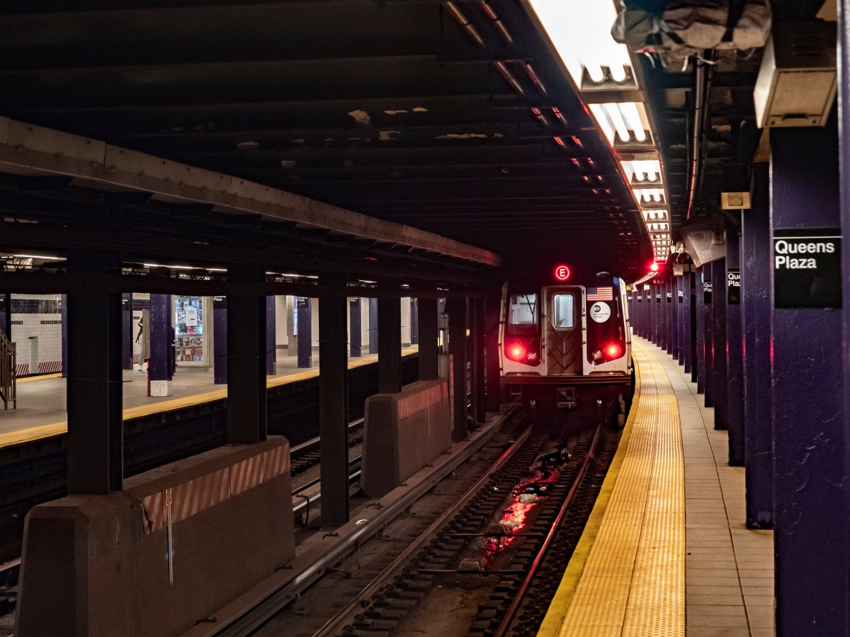 Queens subway station with E train pulling out