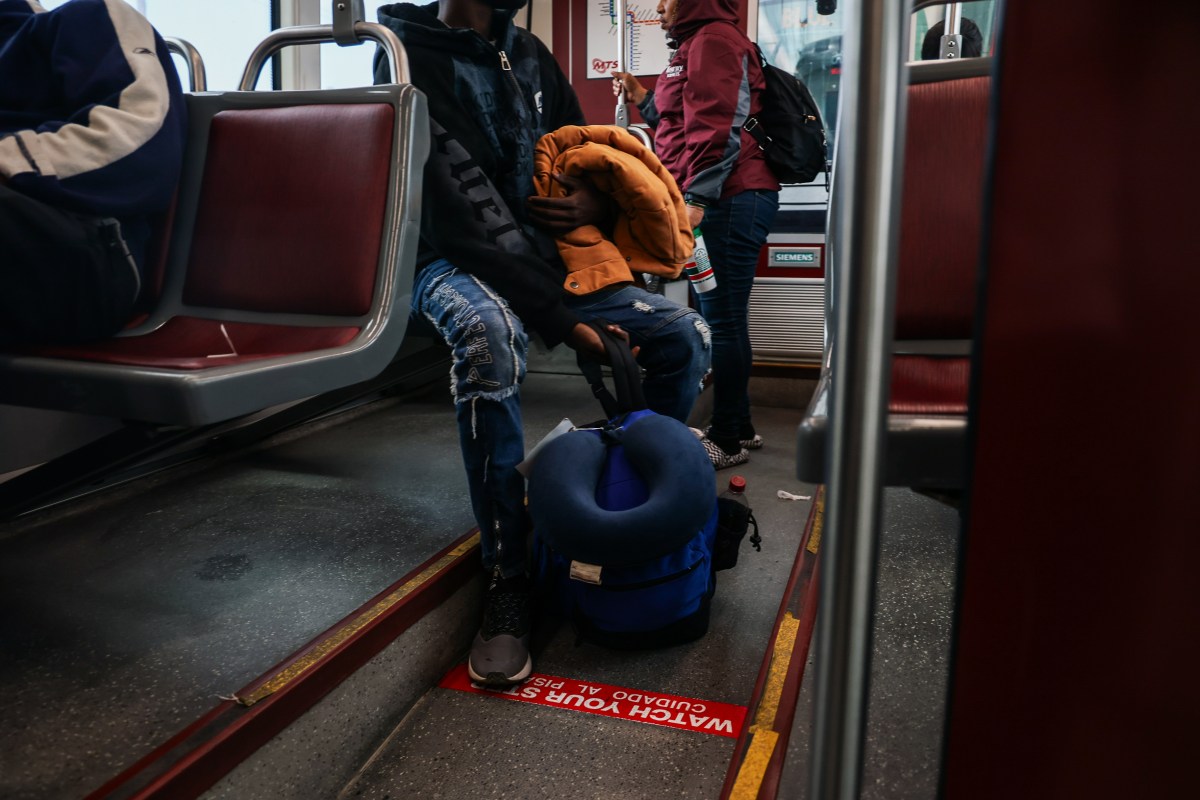 Adoum sits on a bus in California.