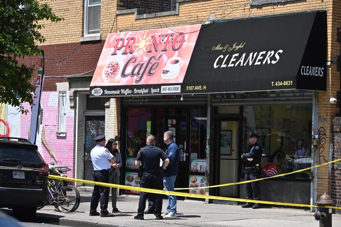 police officer on a sidewalk in Brooklyn in front of stores