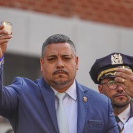 NYPD Commissioner Edward Caban holding up badge