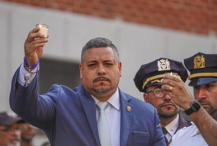 NYPD Commissioner Edward Caban holding up badge