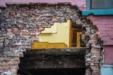 a NYC building facade with a massive hole in it