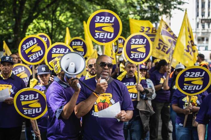 NYC public school cleaners and handypersons wearing purple and holding signs that read 32BJ SEIU