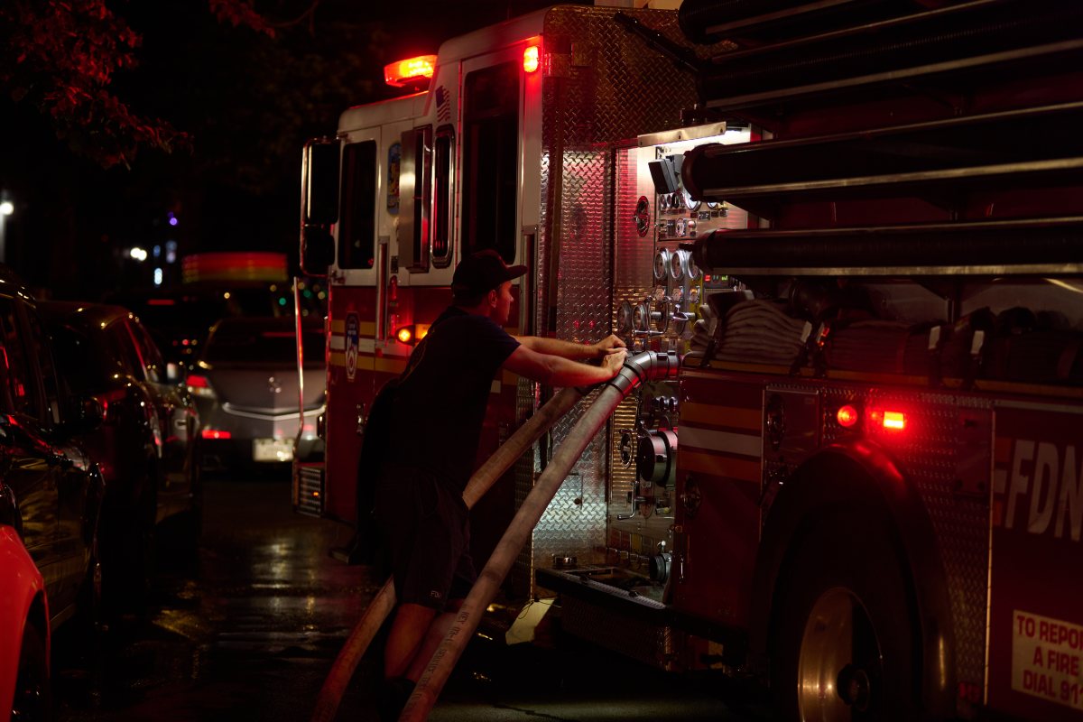 A firefighter pumps water to teammates during a three alarm fire at 298 College Avenue