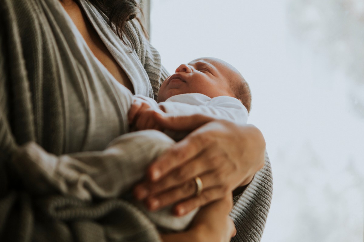 Mother holding her baby indoors