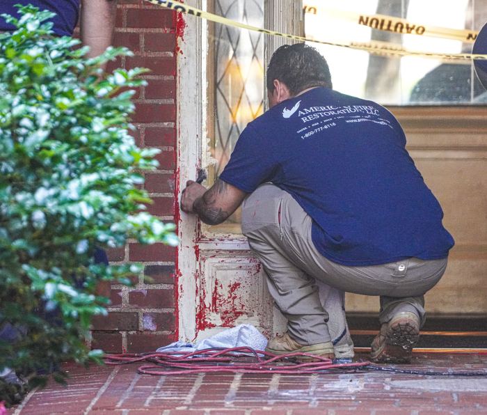 man cleaning up graffiti on Brooklyn building