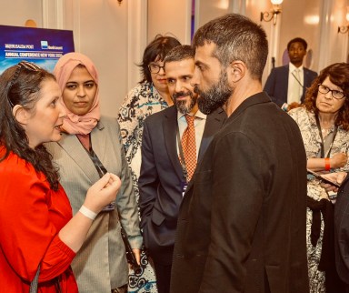 man in black jacket, Mosab Hassan Yousef , speaks with a woman wearing red