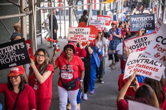 nurses wearing red picketing outside New York Eye and Ear