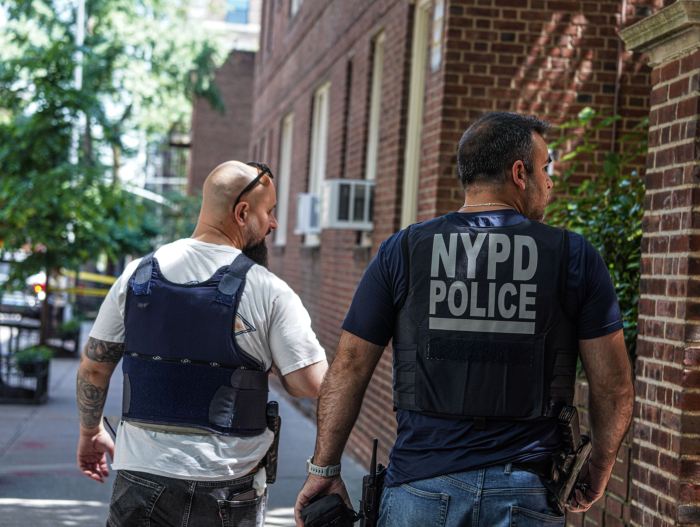 two NYPD officers investigating a crime scene in Brooklyn