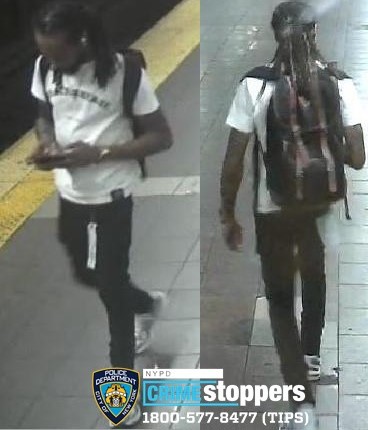 man in white shirt and black pants on platform in Union Square subway station