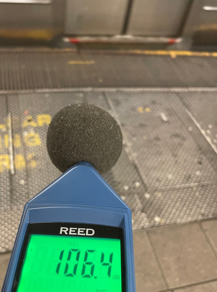 Using a decibelmeter to measure noise levels at a subway station.