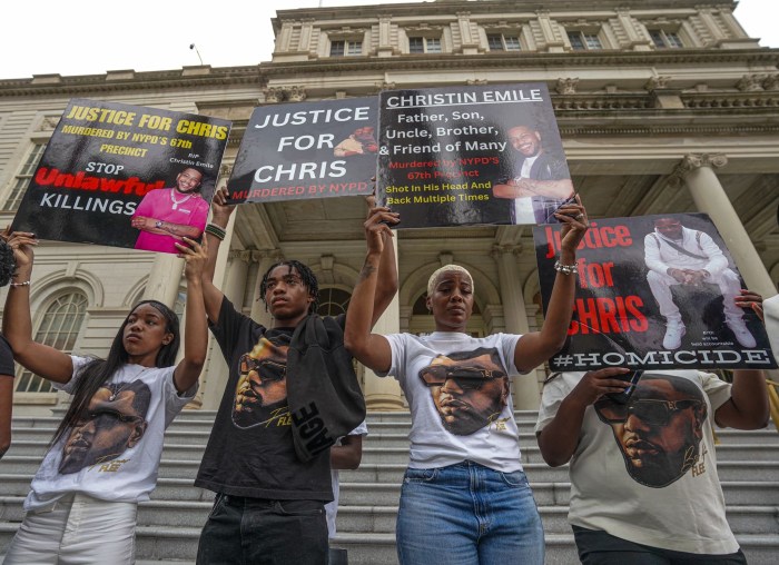 Rally goers hold signs demanding that the NYPD report the truth about Christin Emile's shooting death
