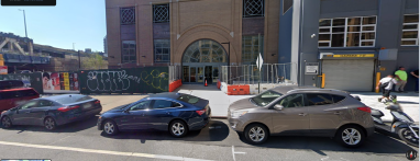 building in Downtown Brooklyn with cars parked in front