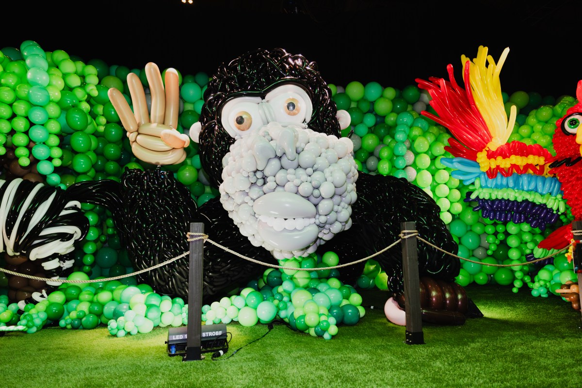 A balloon gorilla waves to visitors.