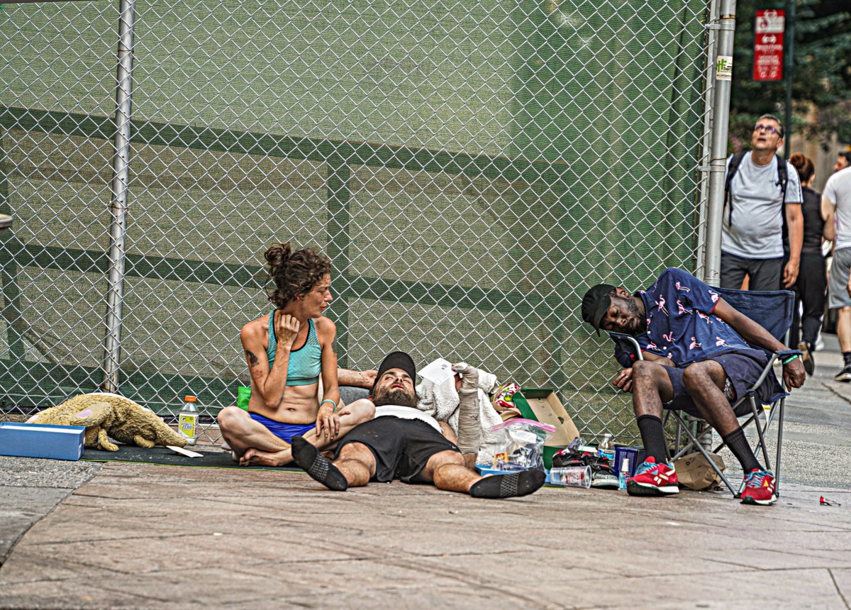 A group of homeless individuals lounge in the sun