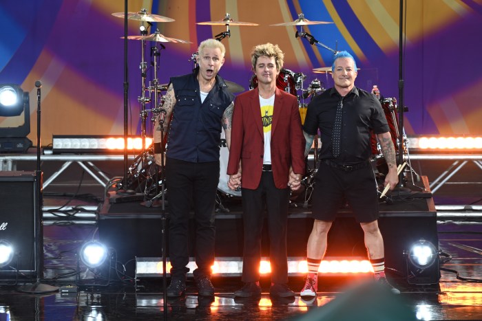 Green Day's Mike Dirnt, Billie Joe Armstrong and Tré Cool standing on stage together