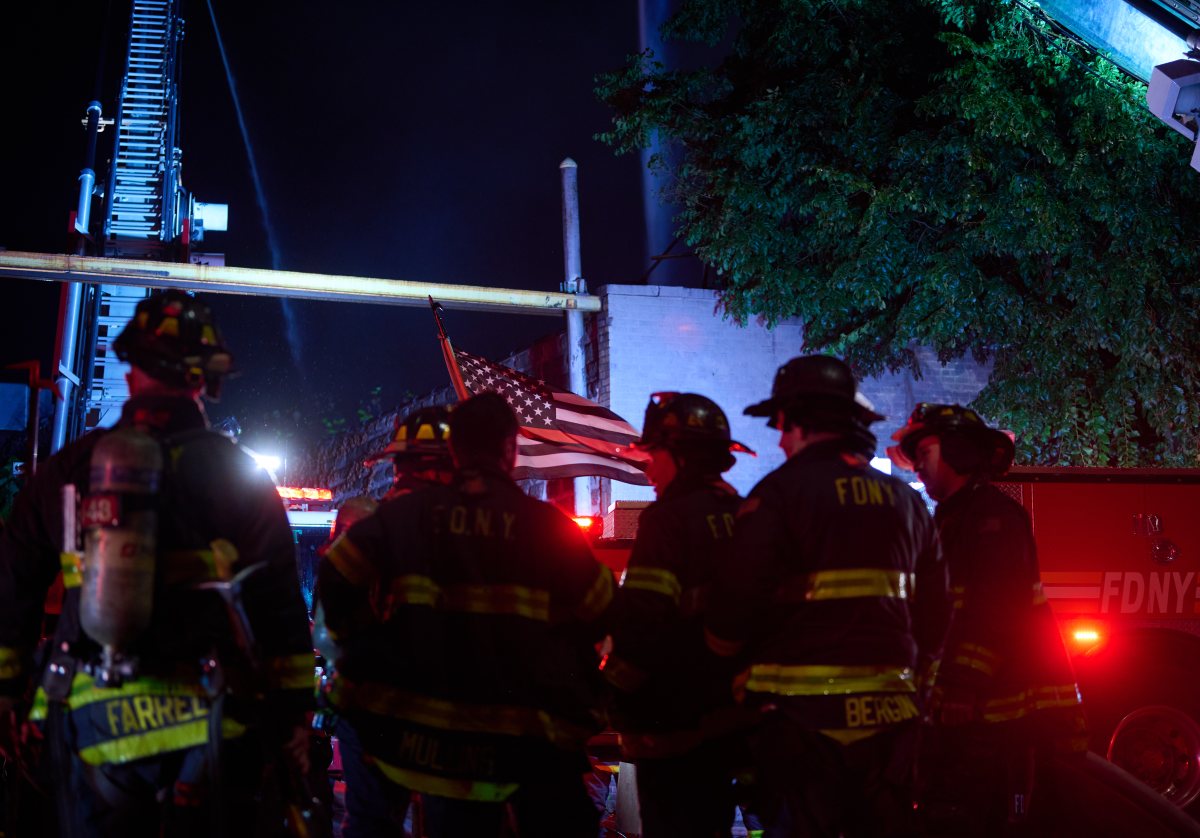 A firefighter works to move hoseline during a tense four alarm fire at 540 Tiffany Street.