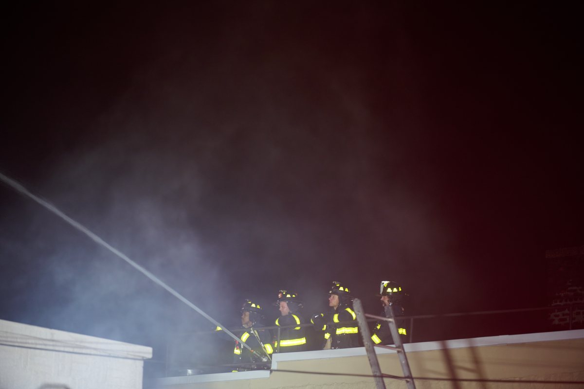 A firefighter works to move hoseline during a tense four alarm fire at 540 Tiffany Street.