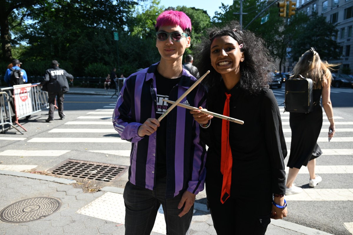 Theo Liao and Linda Smith proudly show off the drumsticks they caught when Tre Cool tossed them into the audience
