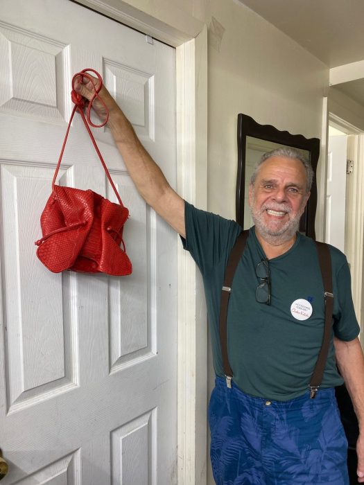 man holding up a red purse at Carlos Falchi studio