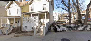 two houses painted in a light color on a clear day during the day in the Bronx