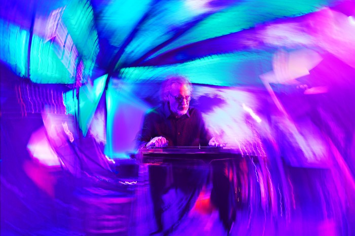 Jonathan Gregg performing on steel guitar with swirling background