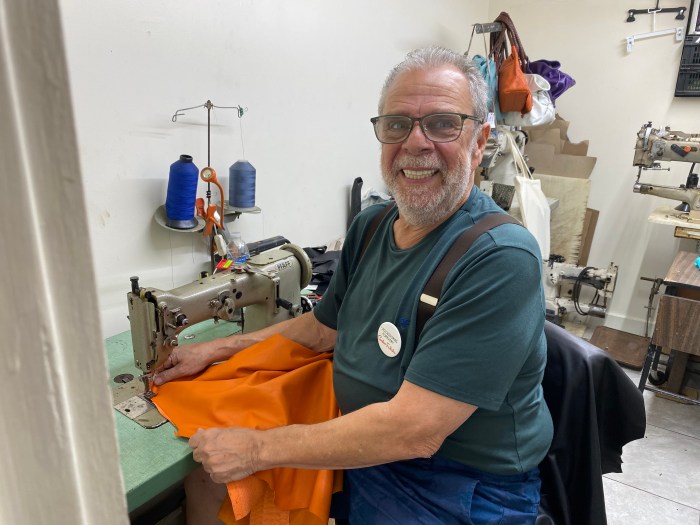 man at a sewing machine at Carlos Falchi handbags studio