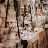 Indoor festive weekend market. Social pop up event of entrepreneurs and makers selling their goods at their booths in shopping mall. Captured with a tilt-shift lens. Selective focus; bokeh effect.