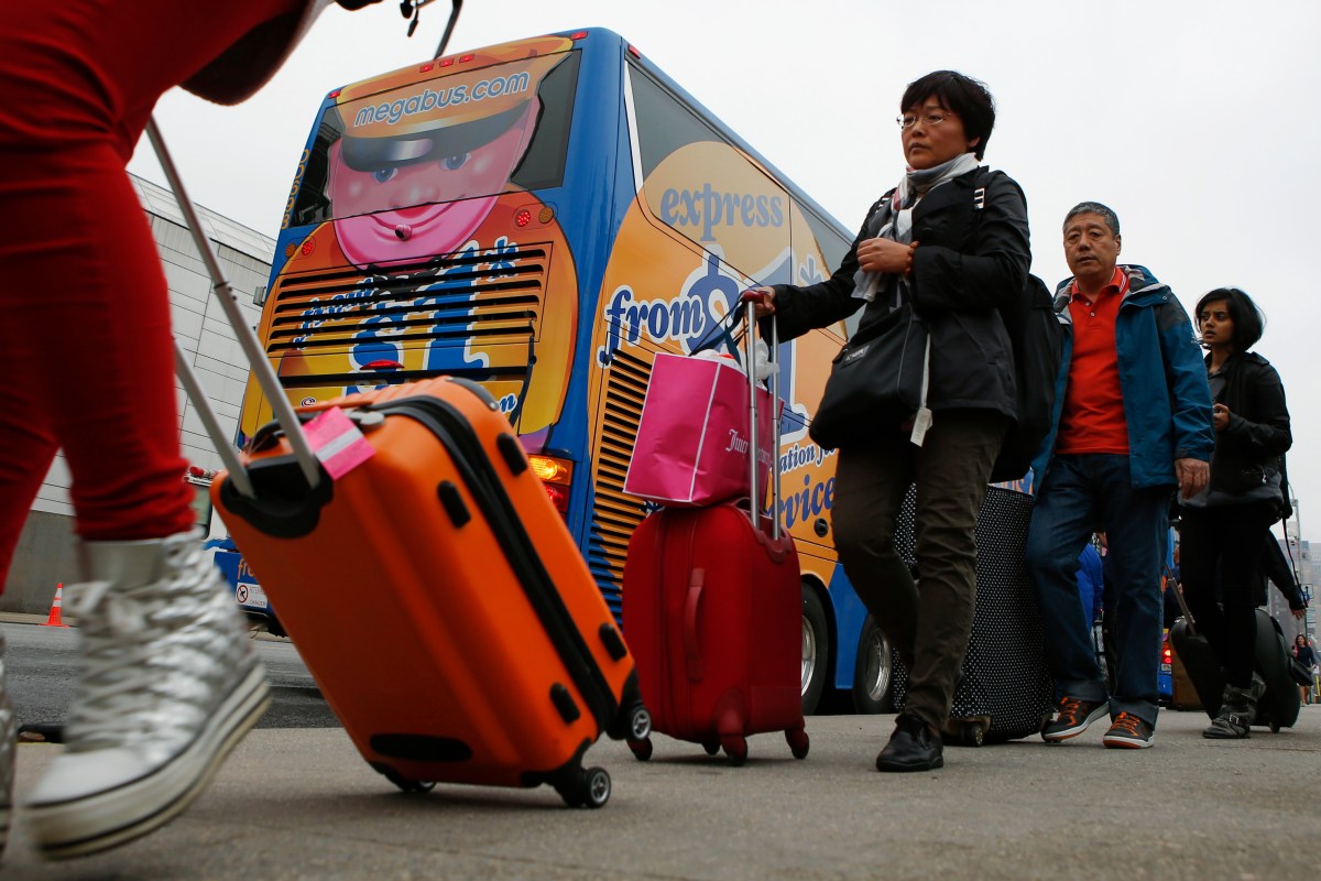 Passengers line up to board a Megabus bus in New York City