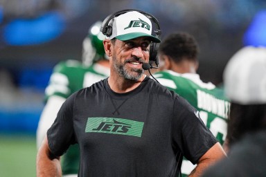 Aaron Rodgers in street clothes on Jets sideline during preseason game