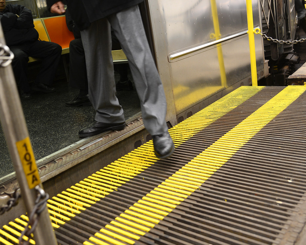 A straphanger gets on a 1 train on the former moving platform at South Ferry.