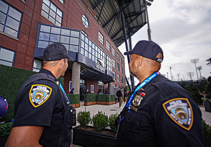 NYPD officers look at Arthur Ashe Stadium during the US Open