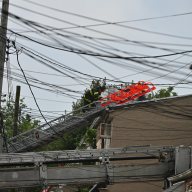 Firefighters battled a three alarm fire at 90-16 80 Street in Queens. A fireman on a ladder is seen at the fire