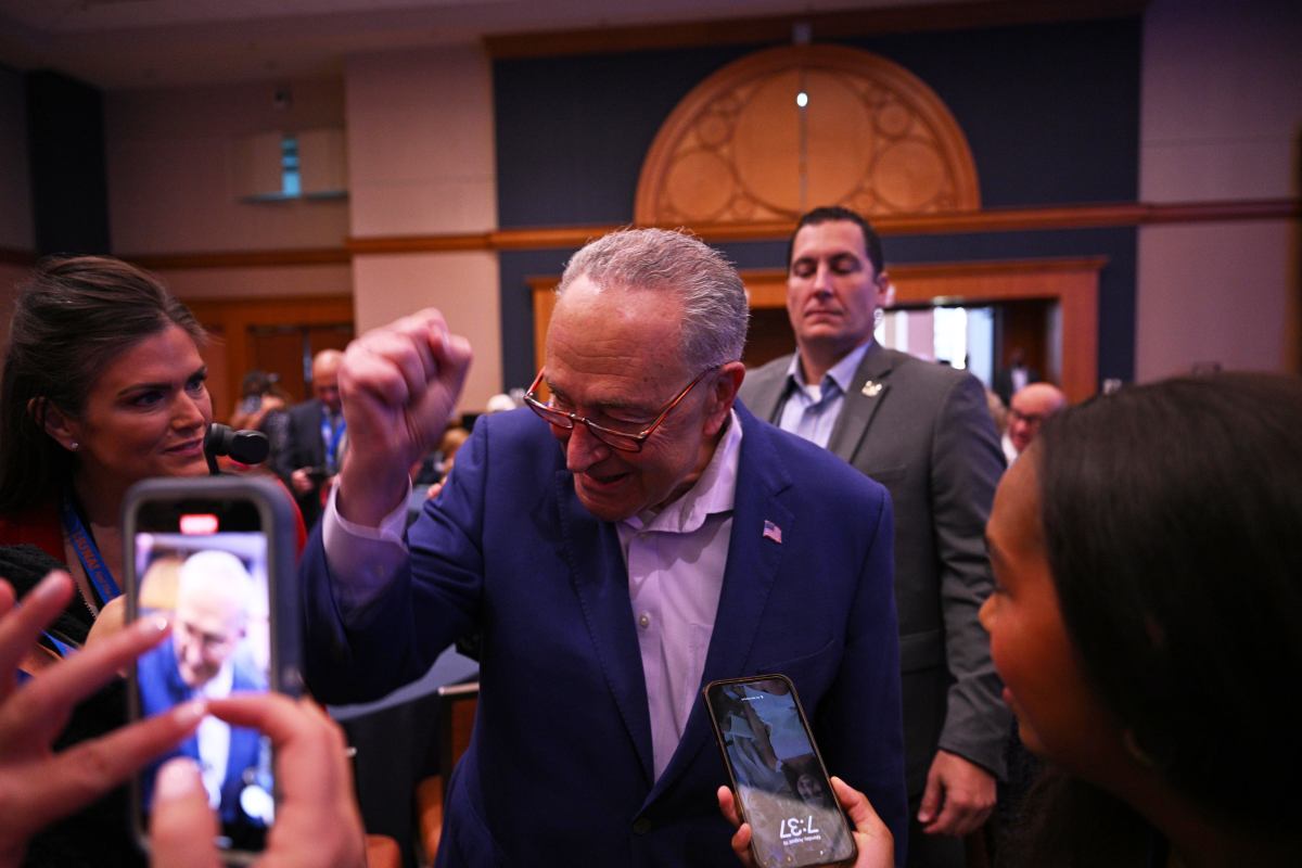 Majority Leader of the United States Senate Chuck Schumer gestures to supports.