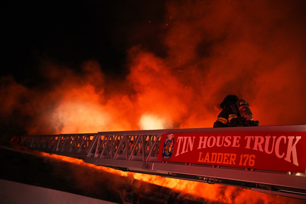 a fireman on a ladder fighting a fire