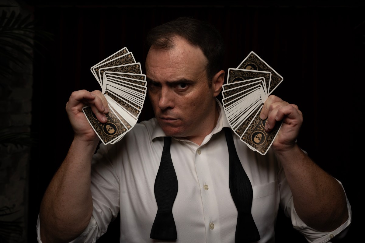 a man holding up playing cards