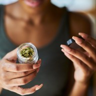 Woman holding container of cannabis