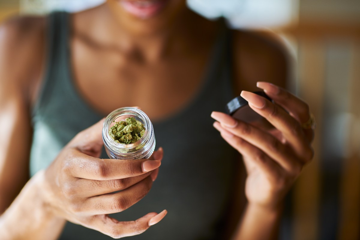 Woman holding container of cannabis