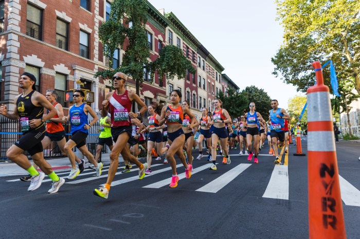 people running in the street in the Percy Sutton 5K Run in Harlem