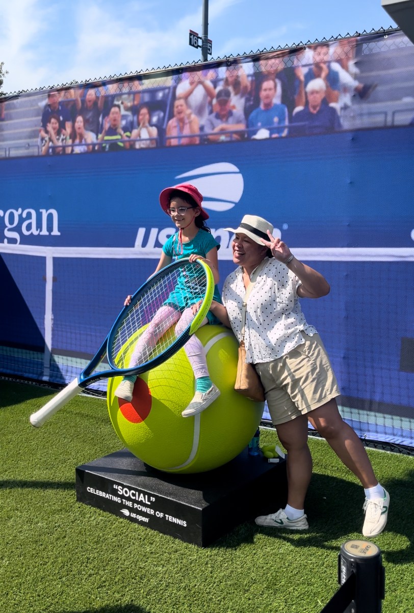 a child sits on a tennis ball sculpture