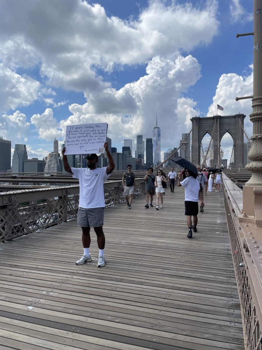 Jose Cruz spreads messages of positivity on the Brooklyn Bridge.