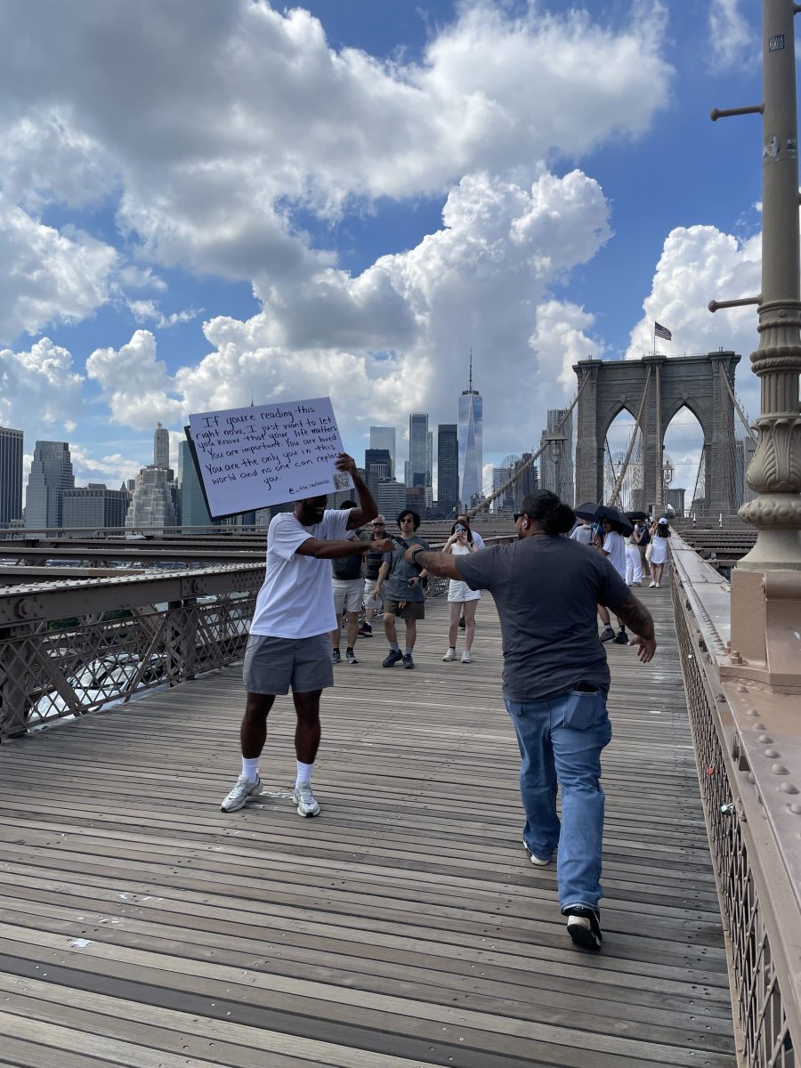 Jose Cruz spreads messages of positivity on the Brooklyn Bridge.