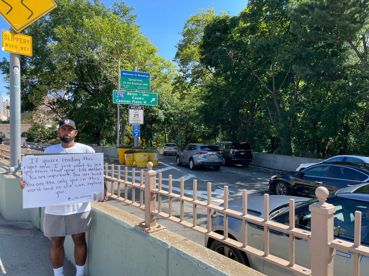 Jose Cruz spreads messages of positivity on the Brooklyn Bridge.