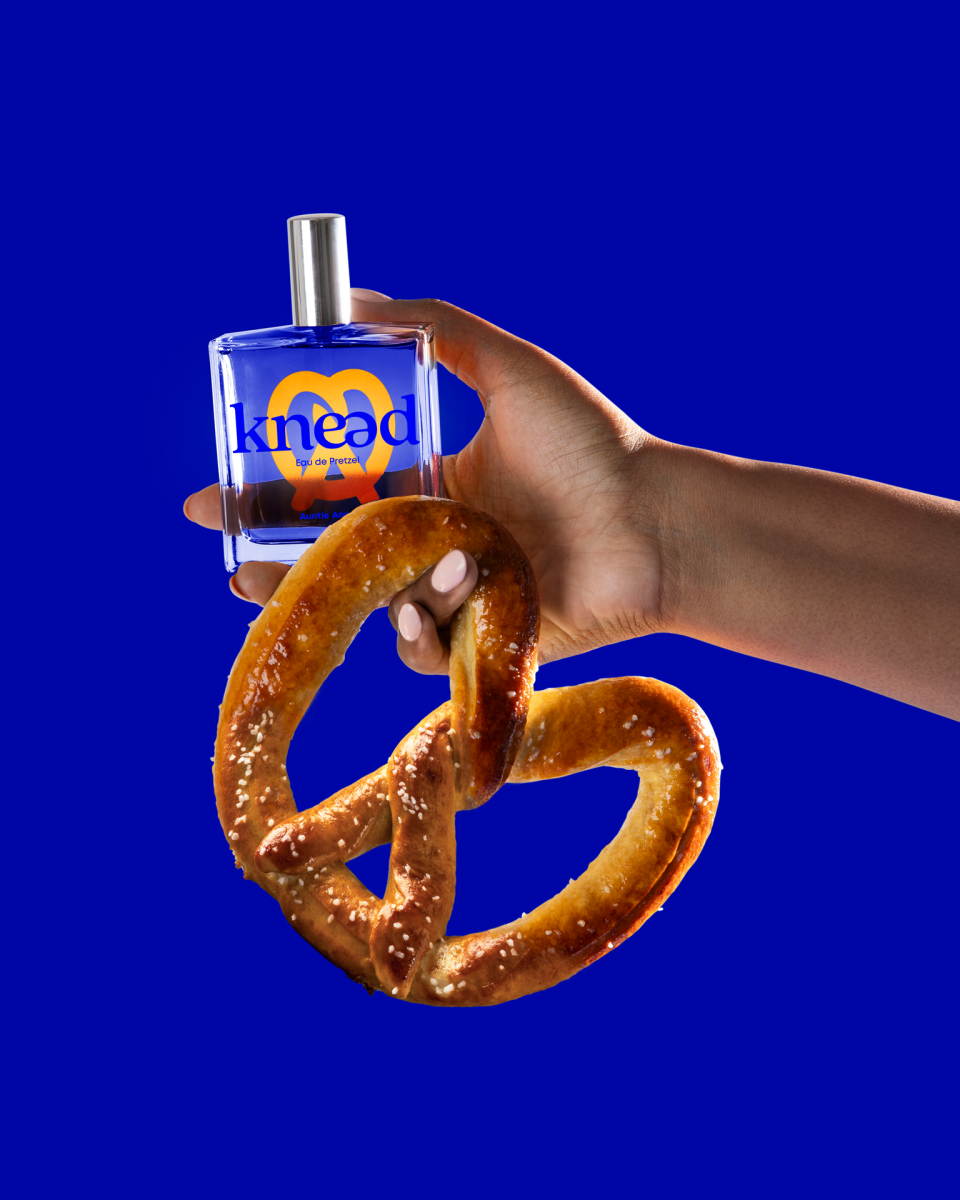 Auntie Anne's Knead perfume being held with a pretzel